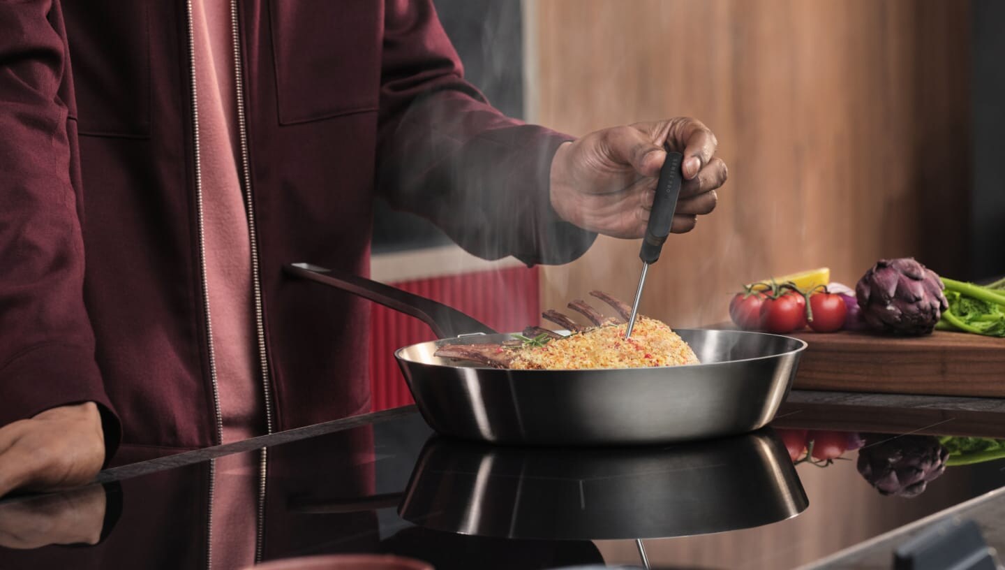Iemand is eten aan het bereiden op een inductiekookplaat.