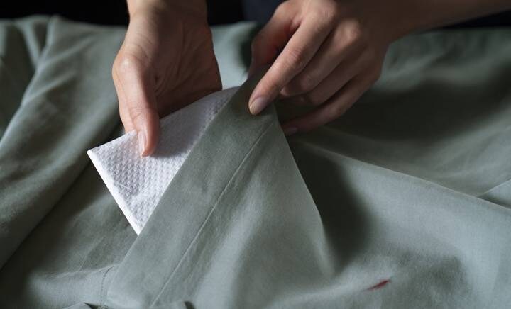 een doek onder het kledingstuk leggen