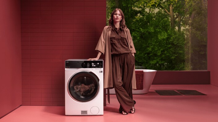 Vrouw naast AEG wasmachine.