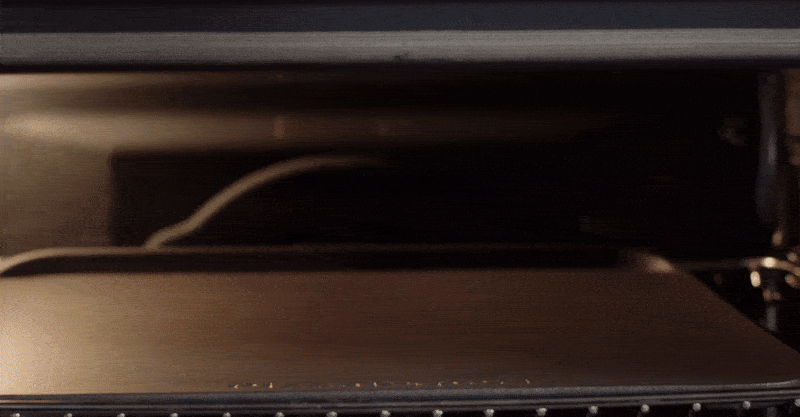 Video van een persoon die pizza maakt met behulp van een oven