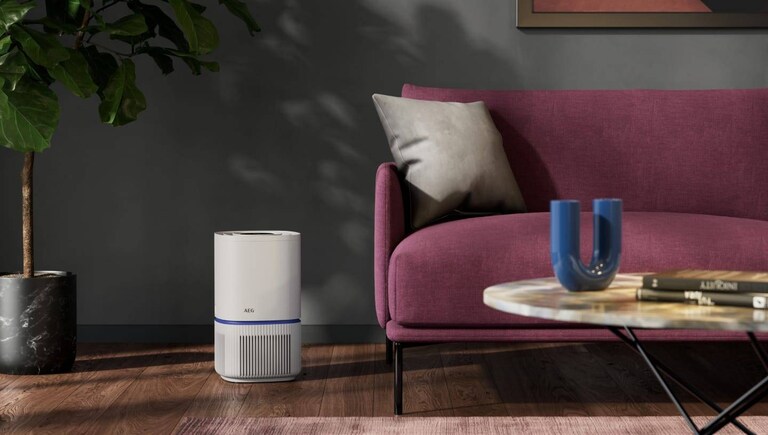 Luchtreiniger naast een bank in een woonkamer