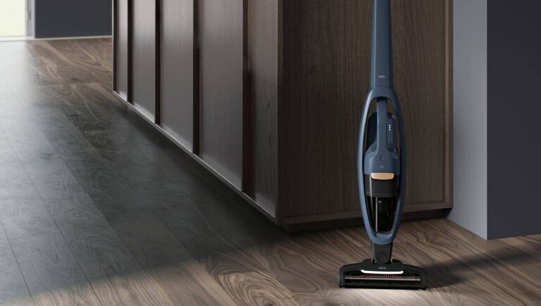 Draadloze stofzuiger van AEG in een gang.