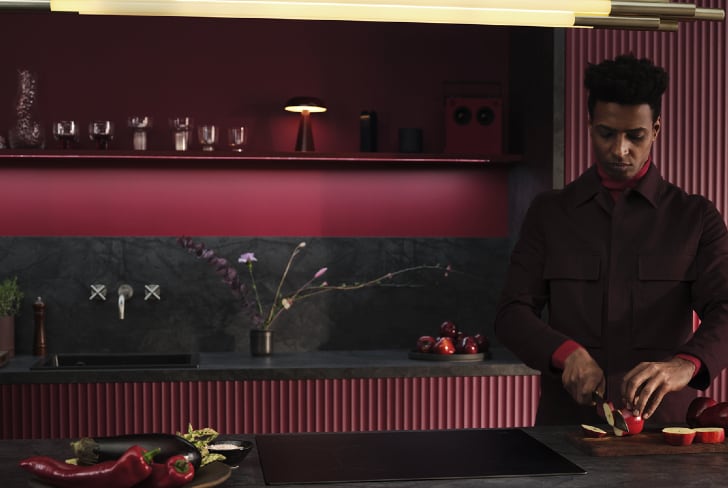 Een man die fruit snijdt in een keuken.