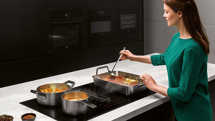 Vrouw kookt aan kookeiland