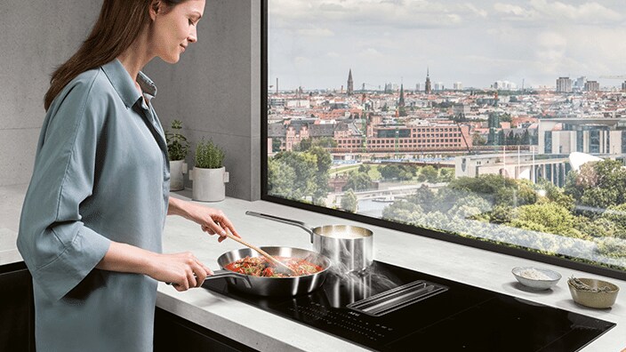 Vrouw kookt aan een raam