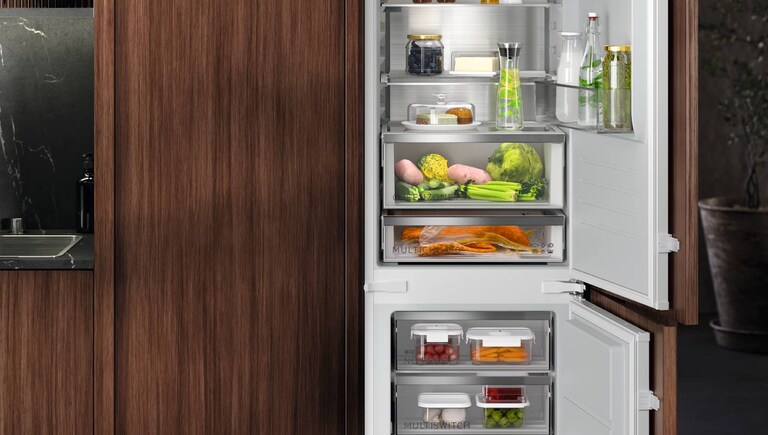 Een ingebouwde AEG koel-vriescombinatie vol met eten.