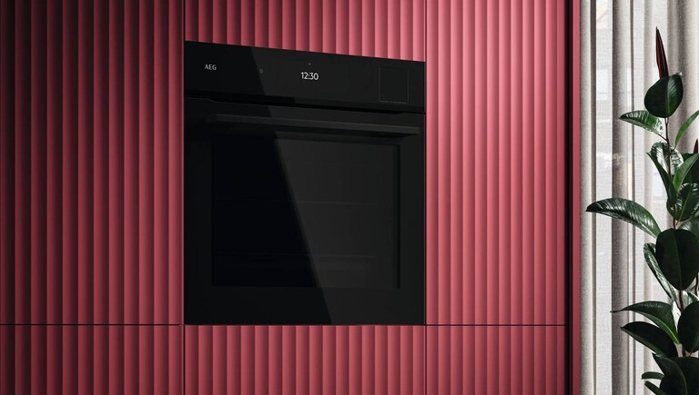 Oven van AEG in een bordeaux rode keuken.