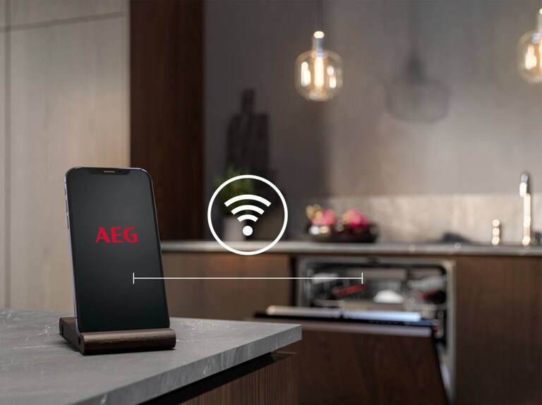 Vaatwasser open met telefoon in de voorgrond